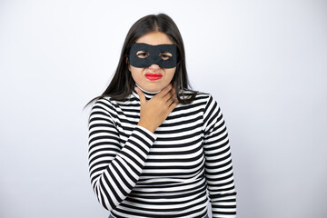 Young beautiful brunette burglar woman wearing mask painful neck, sore throat for flu, clod and infection