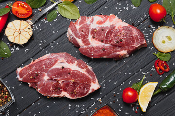 Raw pork chop steak prepare in kitchen with vegetable and spices for food and cooking concept.