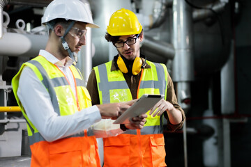 Two maintenance engineers discuss inspect relay checking machinery and repair system in a factory....
