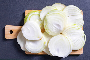 Sliced onion placed on a wooden board. Vegetables in the kitchen prepared to serve.