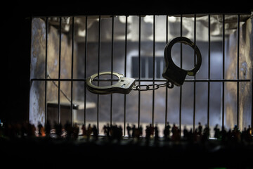 People and police government power concept. Crowd looking on big handcuffs at night with fog and backlight. Creative artwork decoration. Selective focus.