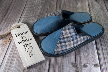 Imagen hogareña,cómodas  zapatillas de color azul sobre el suelo de madera de una casa.