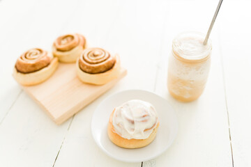 Sweet roll with cinnamon and frosting served with cold coffee