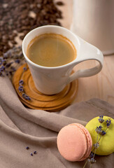 cup of coffee and coffee beans in a sack on dark background, top view