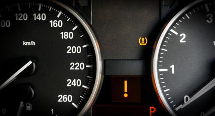Closeup of lose tyre pressure alert in dashboard car on background.	