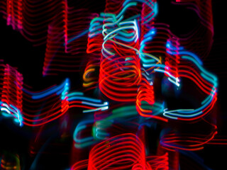light painting photography, waves of vibrant color against a black background. Long exposure photo of vibrant fairy lights in abstract