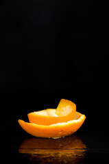 Freshly Cut Orange Peel on Dark Wet Background Vertical