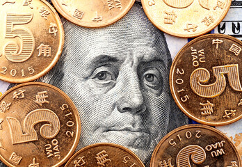 Franklin's head portrait on one hundred dollars surrounded by chinese coins