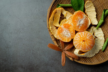 Peeled tangerines on old dark background