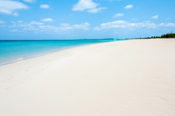 Fototapeta na wymiar White sand beach with wind texture and a beautiful turquoise sea behind.