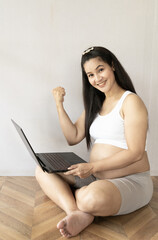 Fototapeta premium Asian pregnant mother smile and very happy. She working and shopping online.