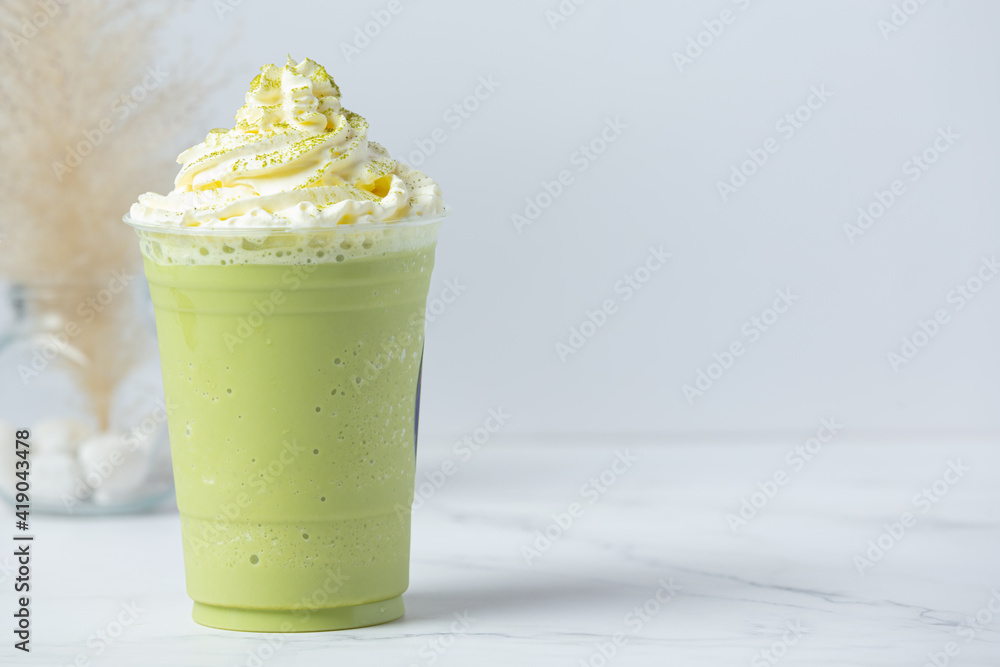 Wall mural green tea smoothies with whipped cream on white background