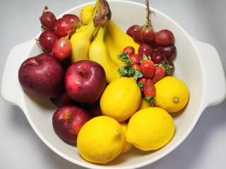 Close Up Fruits on Plastic Container. Banana, Grape, Apple And Strawberry. Blurry Background