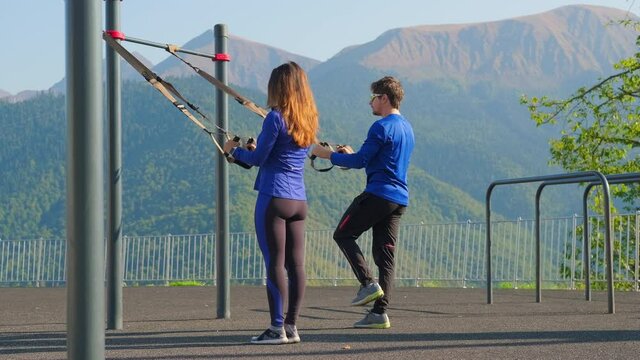 Couple training together using trx straps