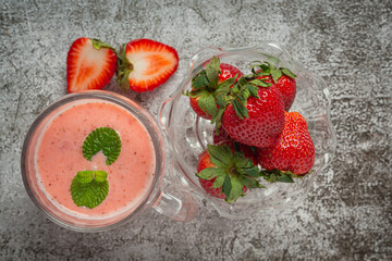 Strawberry smoothie in glass on old dark background