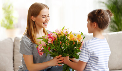 Fototapeta na wymiar Girl giving flowers to woman on Mothers Day
