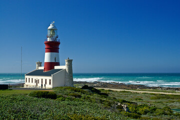 Fototapeta na wymiar The red and white Cape Agulhas Lighthouse at the southern tip of Africa, where the Atlantic and Indian Oceans meet