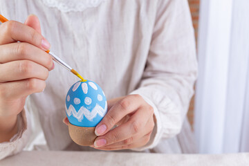 Asian young woman painting Easter eggs