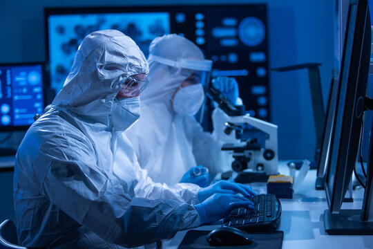 Professional team of scientists is working on a vaccine in a modern scientific research laboratory. Genetic engineer workplace. Future technology and science concept.