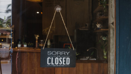 Sorry we're closed vintage black and white retro sign on a coffee glass door cafe after coronavirus lockdown quarantine. Owner small business, food and drink, business financial crisis concept.