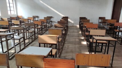 Interior of a typical classroom with wooden chair and stool  arranged in a straight line and column