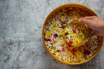 Thai traditional jasmine garland and Colorful flower in water bowls decorating and perfume, marly limestone, plastic water gun on table