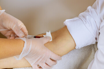 Laboratory nurse takes blood sample from arm on the analysis