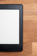 Closeup image of an electronic reader with blank screen on a wooden surface