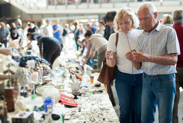 Fototapeta na wymiar Elderly man and woman consider things in flea market. High quality photo