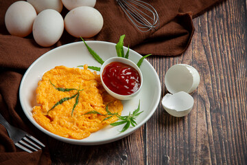 Egg omelet with marijuana leafs on old dark background