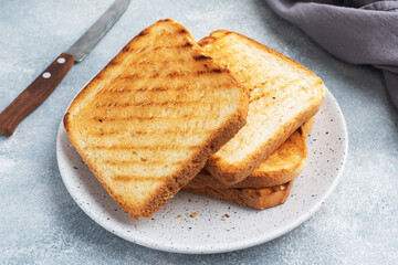 Bread toast crispy for sandwiches on a plate on a gray concrete table.
