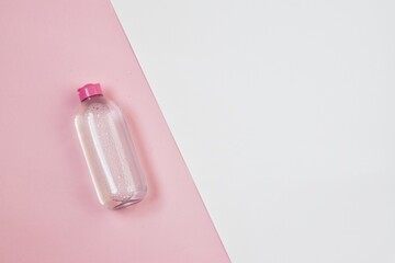 Face care products (tonic or lotion, serum, cream, micellar water) on pink-white background. Freshness natural anti-age care. Female everyday fresh cosmetics. Copy space. Flat lay.