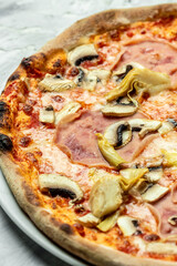 capriciosa pizza. Italian pizza is cooked in a wood-fired oven. vertical image, Food recipe background. Close up. top view