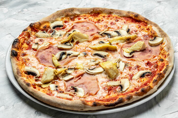 Italian pizza capriciosa mushroom artichokes, tomato and mozzarella cheese. Food recipe background. Close up