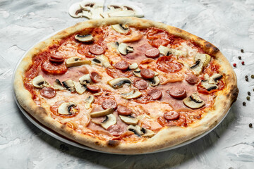 Italian pizza capriciosa mushroom tomato and mozzarella cheese. baking in the oven in traditional restaurant