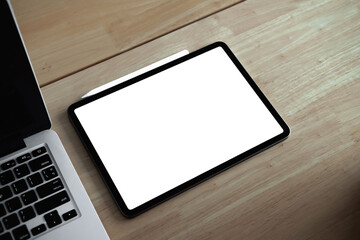 Cropped shot of mock-up digital tablet with blank white screen on desk.