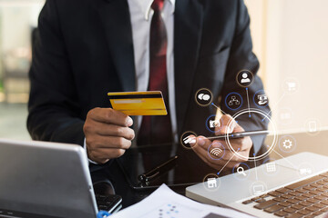 Businessman hold credit cards, conduct financial transactions via smartphone tablets and data documents put on the desk in the morning.