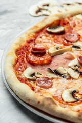 Tasty Capriciosa pizza. Classic pizza with ham and mushrooms. Italian pizza is cooked in a wood-fired oven. vertical image, Food recipe background. Close up