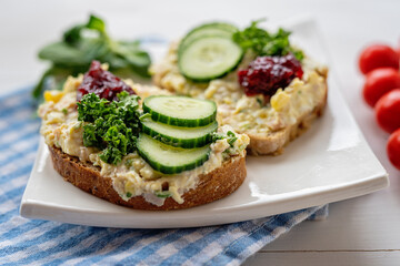 sandwich dip bread spread with salad vegetables on white porcelain plate 