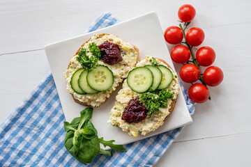 sandwich dip bread spread with salad vegetables on white porcelain plate 