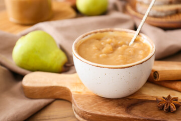 Bowl of tasty pear jam on wooden table