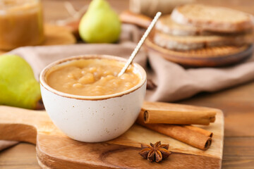 Bowl of tasty pear jam on wooden table