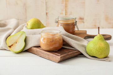 Jar of tasty pear jam on wooden table