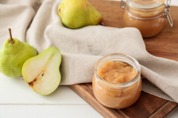 Jar of tasty pear jam on wooden table