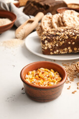 Fototapeta na wymiar Bowl with corn grains and different products on light background, closeup