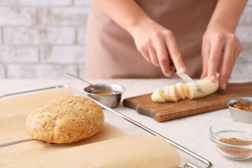 Obraz na płótnie Canvas Woman cooking banana cookies in kitchen