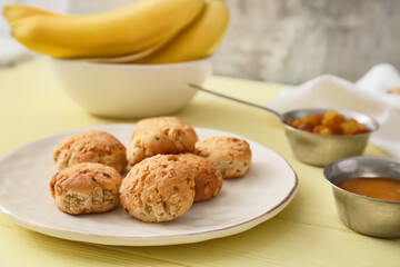 Plate with tasty banana cookies on color wooden background