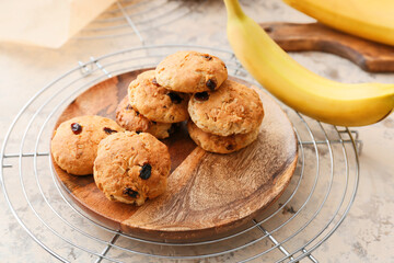 Plate with tasty banana cookies on light background