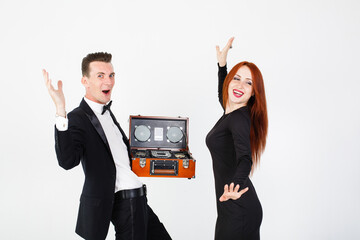 Couple young man and woman singing and dancing together with retro music CD player in hands, white...