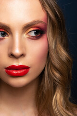 Fototapeta premium Close-up portrait of a beautiful model with a bright make-up and red lips.